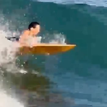 Shot of a female swimmer surfing in an ocean. Swim suit, adult female.